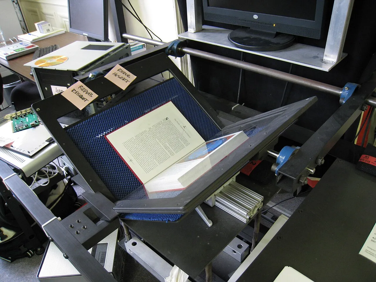 A book scanner at the Internet Archive headquarters holding an open book for digitisation